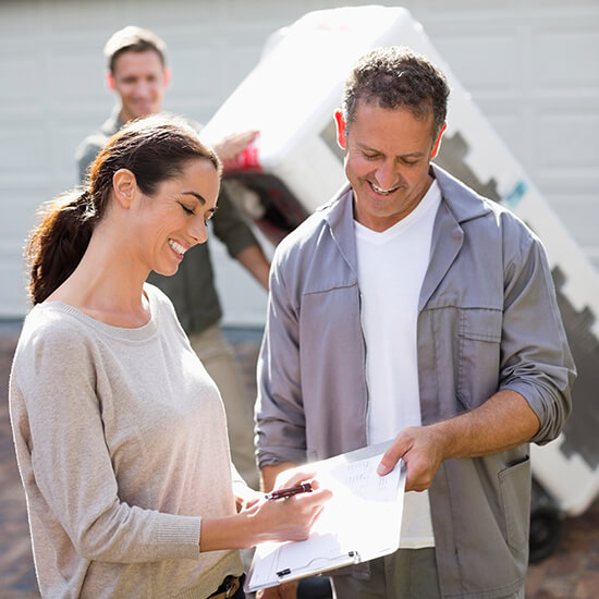 Woman signing for delivery in driveway